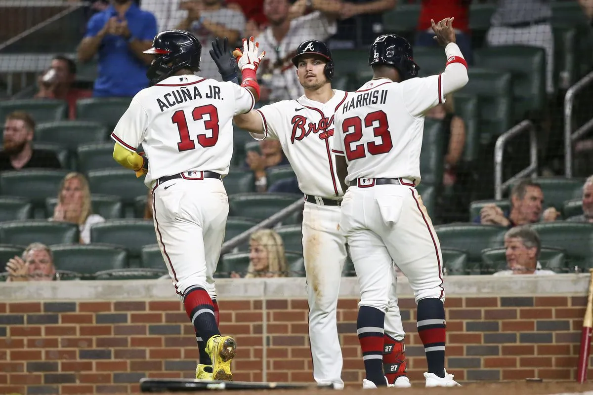 Ronald Acuña Jr., Michael Harris II, and Austin Riley celebrate during a game in Atlanta. 